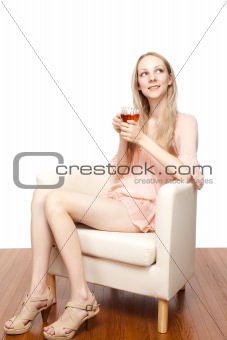 Beautiful young woman drinking tea sitting