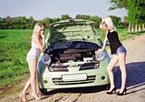 Two sexy blonde girls stand by the broken car 