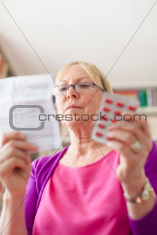 Senior woman with medication pills and prescription
