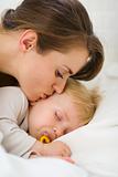 Closeup on mother kissing sleeping baby