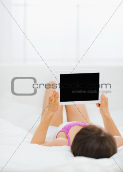 Woman laying in bed and holding tablet PC