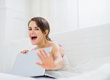Woman hiding what she looking on laptop