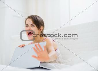 Woman hiding what she looking on laptop