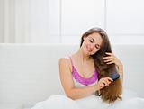 Dreaming woman combing beautiful long hair