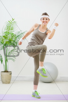 Happy fitness woman making gymnastics