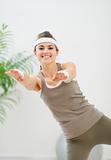 Smiling healthy woman making gymnastics exercise
