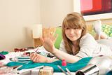 Teenage Girl In Untidy Bedroom Painting Nails