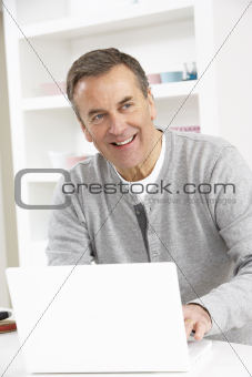 Senior Man Using Laptop At Home