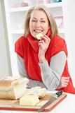 Senior Woman Making Sandwich In Kitchen