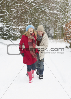 Couple Walking Through Snowy Woodland