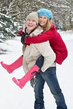 Man Giving Woman Piggyback In Snowy Woodland