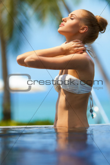 Pretty girl massaging her neck after a swim
