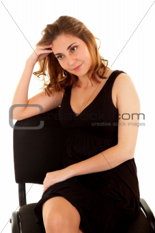 Thinking woman in a black dress on a chair