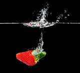 fresh strawberry dropping into water