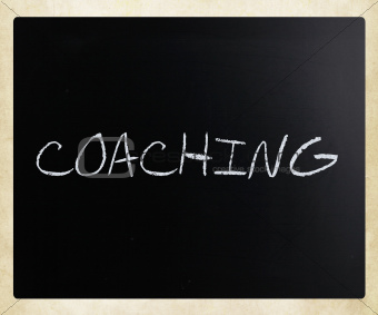 "Coaching" handwritten with white chalk on a blackboard