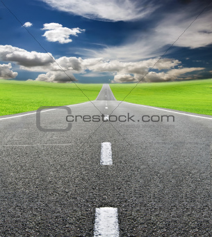 green field and road over blue sky