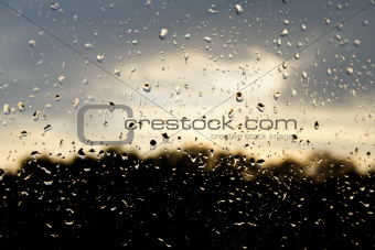 Rain drops on the glass against sky background