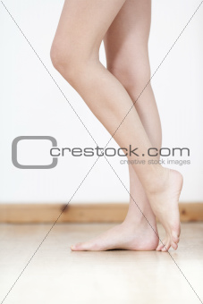 Womans legs against white wall