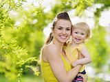 Portrait of smiling mother and baby girl outdoors