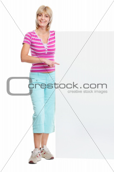 Smiling middle age woman pointing on blank billboard
