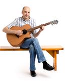Handsome casual man with guitar sitting on bench