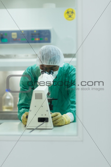 Man at work with microscope in biotechnology lab