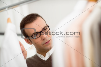 adult man choosing shirt in clothes shop