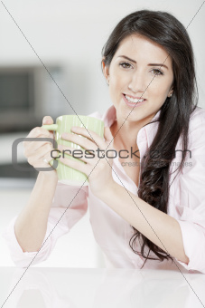 Young woman sat at table with drink
