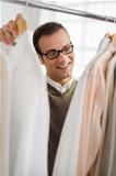 adult man choosing shirt in clothes shop