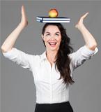 Woman balancing apple and books on head
