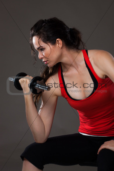 Beautiful young  woman lifting weights