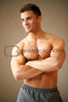 Smiling handsome man with muscular arms crossed