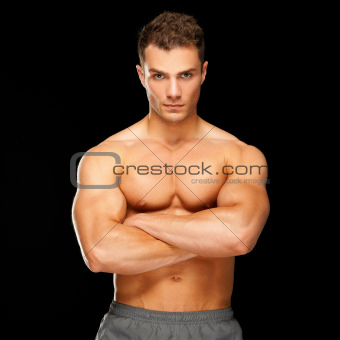 Handsome man with arms crossed looking his left on black