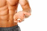 Close up of muscular man torso with hand full of pills