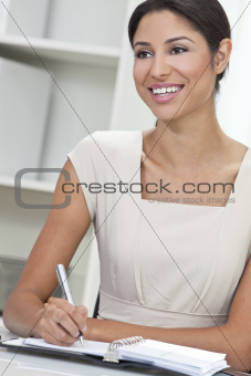 Hispanic Latina Woman or Businesswoman in Office Writing