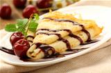 Sweet pancake with chocolate sauce and cherries