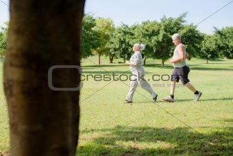 Active senior people jogging in city park