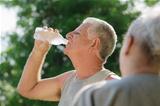 Seniors drinking water after fitness in park