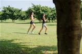 Sport with two young women jogging in city park