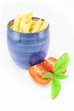 Pens pasta in a blue jar with tomatoes and basil