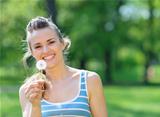 Happy young woman with dandelion