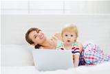 Mother and surprised baby using laptop
