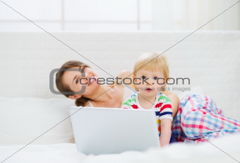 Mother and surprised baby using laptop