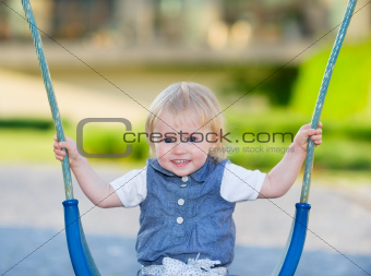 Happy baby sitting on swing