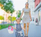 Happy baby walking with mom in city