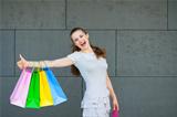 Smiling woman with shopping bags showing thumbs up