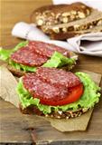 sandwich with sausage salami, lettuce and tomato