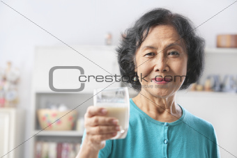 Senior woman holding glass of milk