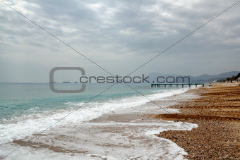 Beach with pier at the mediterranean sea