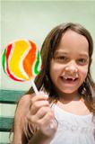 Portrait of pretty female child with lollipop smiling
